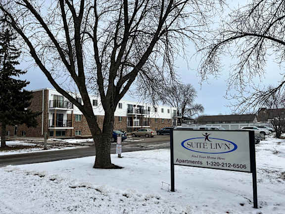 A sign for Suite Liv’n apartments is in the snow