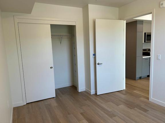 A room with a white door and a white closet with a hanger at 26FIFTY Apartments, Berkeley 94704