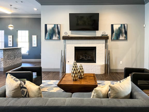 a living room with a couch and a table and a fireplace at The Madison Apartment Homes in TX 75703