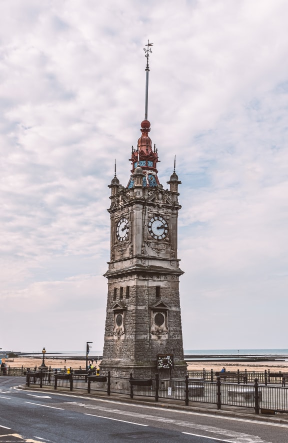 a large clock tower on the side of a road