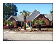 a house with balloons and a sign in front of it
