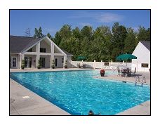 a large swimming pool with a house in the background