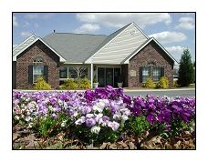 a house with a bunch of flowers in front of it
