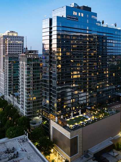A tall building with a blue sign on the top stands out among other buildings at 903 Peachtree in Atlanta, 30309