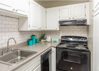 A kitchen with a black oven and white cabinets.