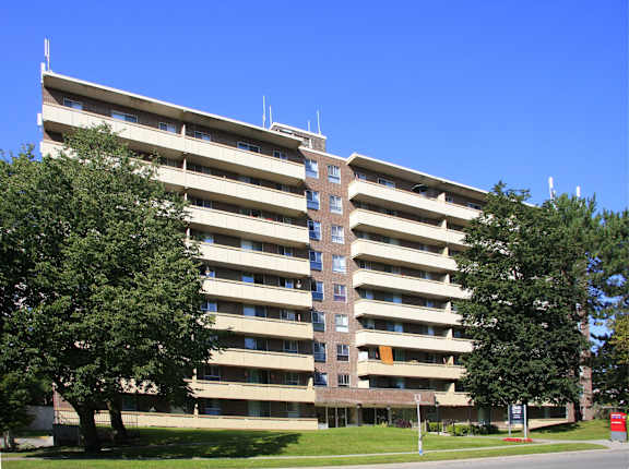 an apartment building on the corner of a street with trees