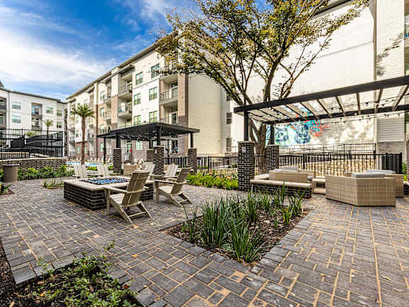 an outdoor patio with tables and chairs and a building in the background