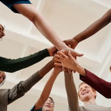 a group of people putting their hands on top of each other