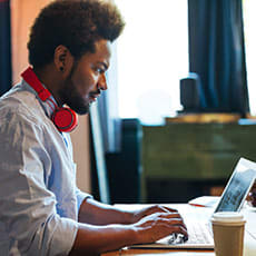 Man with headphones typing at a computer