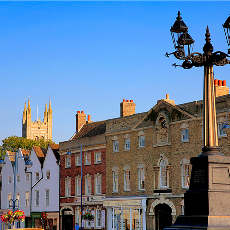 A street scene with a large building in the background and a street light in the foreground.at Penny Green Apartments, St Neots, WINTRINGHAM, PE19 0AJ