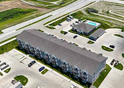 Apartment complex with a swimming pool and a parking lot.