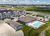 Thumbnail 4 of 11 - A large apartment complex with a swimming pool.