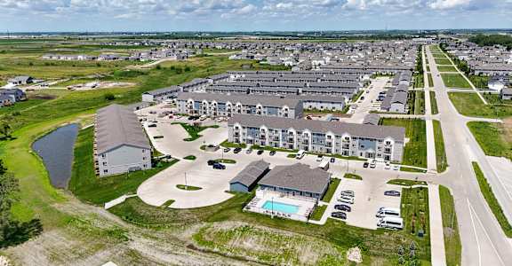 A bird's eye view of a residential area with houses and a swimming pool.