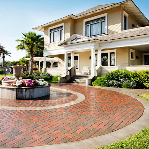A house with a red brick walkway in front of it.