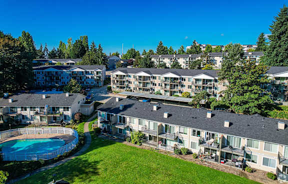 A swimming pool is surrounded by apartment buildings.