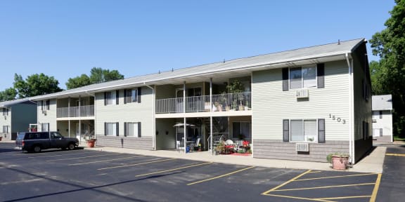 an apartment building with a parking lot and a black truck