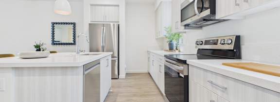 A modern kitchen with white cabinets and a large island.