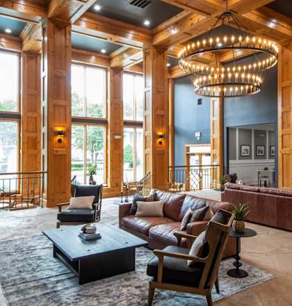 A large, well-lit living room with a fireplace and a large chandelier.