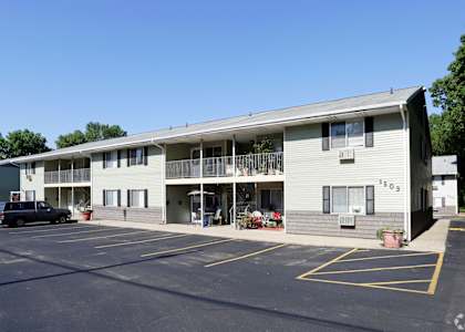 an apartment building with a parking lot and a black truck