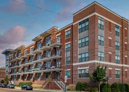 A large red brick building with a balcony on the second floor.