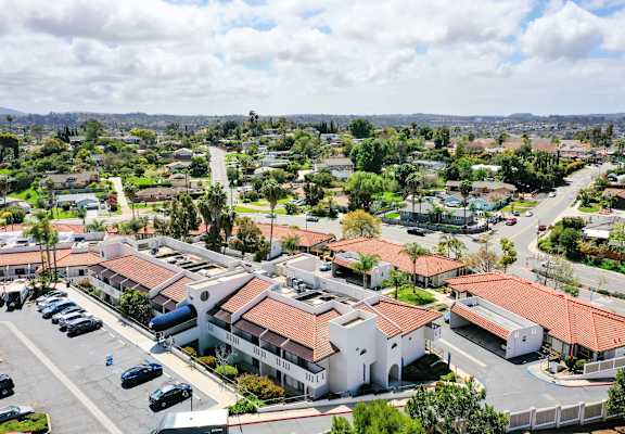 A view of a residential area with houses and parked cars.