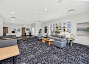 Thumbnail 1 of 11 - A spacious office lobby with a grey carpet and modern furniture.