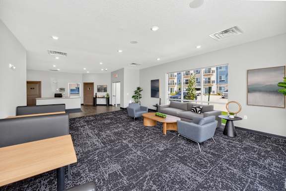 A spacious office lobby with a grey carpet and modern furniture.