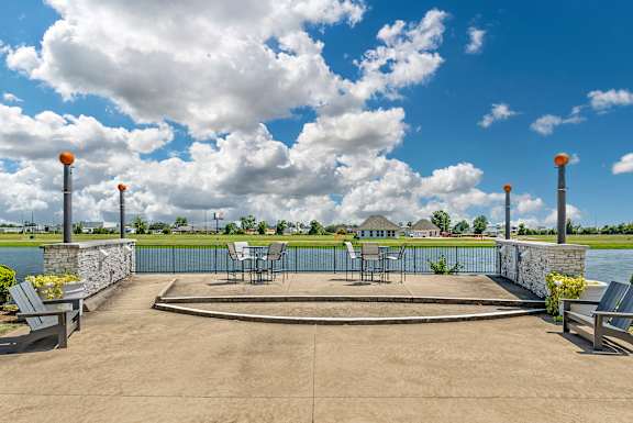 Patio with tables and chairs overlooking a body of water