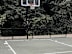 A basketball is on the ground near a basketball hoop.