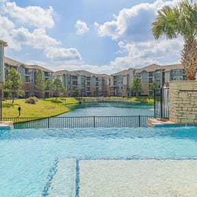 a large swimming pool with an apartment building in the background