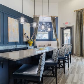 a kitchen with blue cabinets and a long island with blue chairs