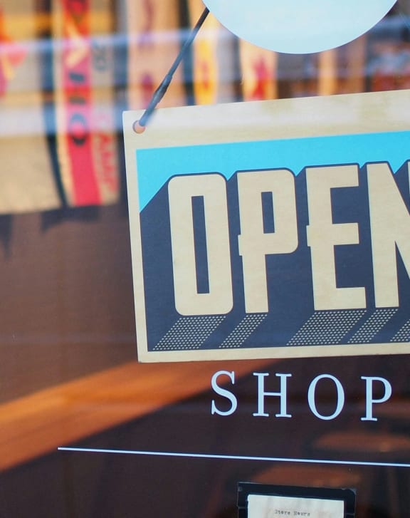 a blue open shop sign in the window of a store