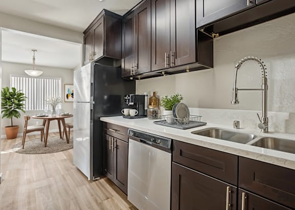 a kitchen with black cabinets and stainless steel appliances and a white counter top