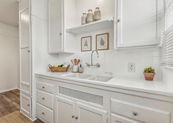 a kitchen with black cabinets and stainless steel appliances and a white counter top