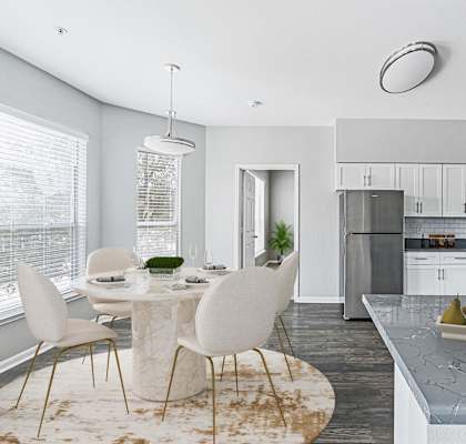 a kitchen with white cabinets and a gray counter top and a white table with white chairs