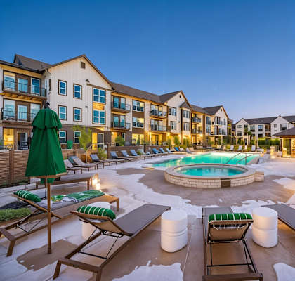 A large outdoor pool area with lounge chairs and umbrellas.