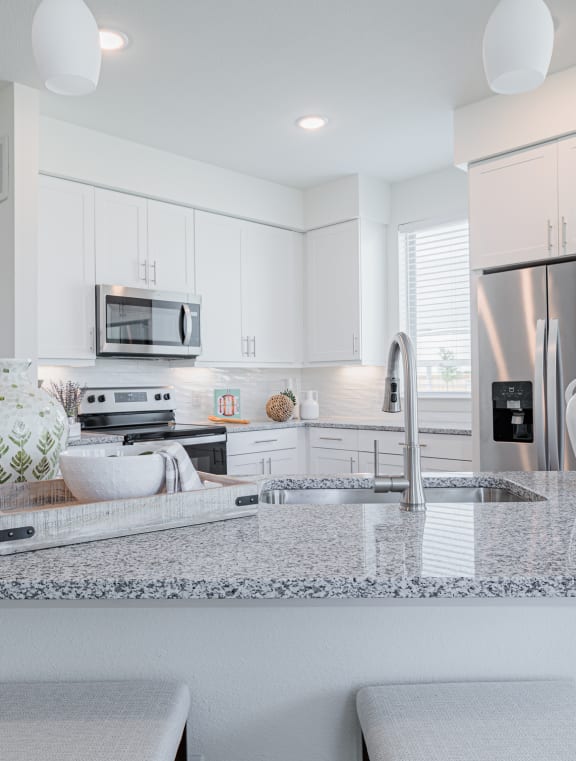 a kitchen with white cabinets and a granite counter top