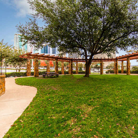 Green space with trees and a picnic bench at Firestone at West 7th. 