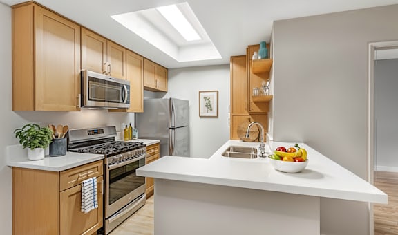 A modern kitchen with wooden cabinets and stainless steel appliances.