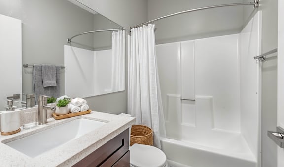 A white bathroom with a towel on the counter.