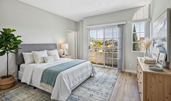 A bedroom with a large bed and a view of the outside through the window.