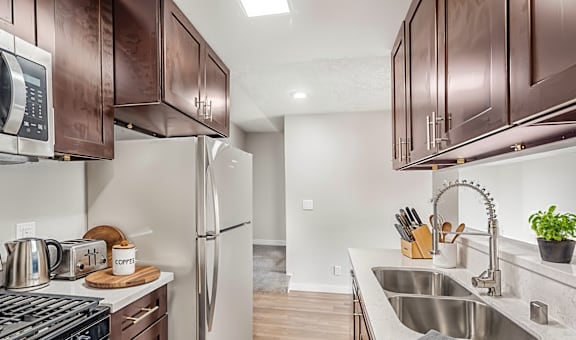 A kitchen with brown cabinets and a stove top oven.