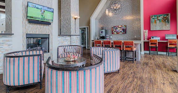 a clubhouse with tables and chairs and a fireplace