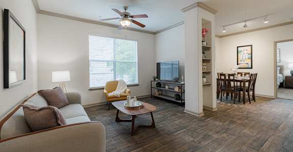 a living room with a couch and a chair and a ceiling fan