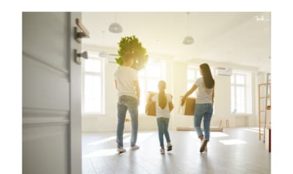 a family carrying boxes into an empty house