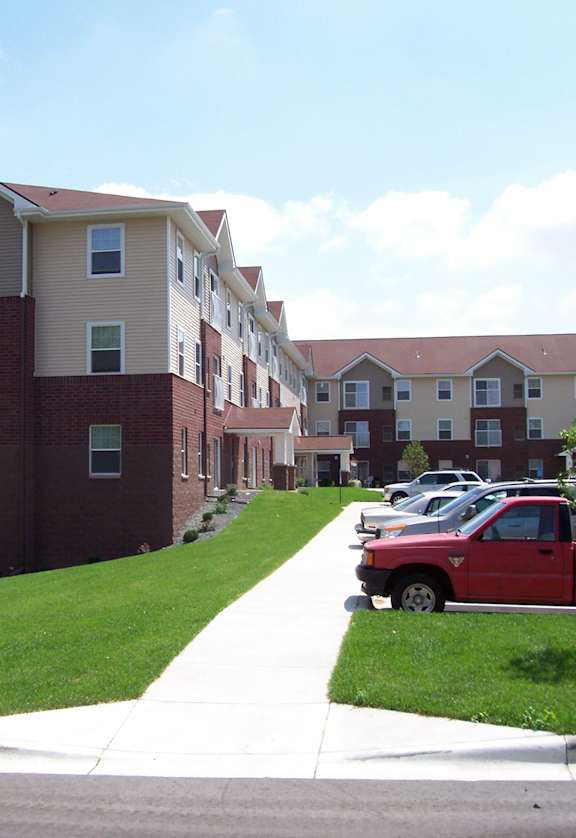 A red truck is parked in front of a building.