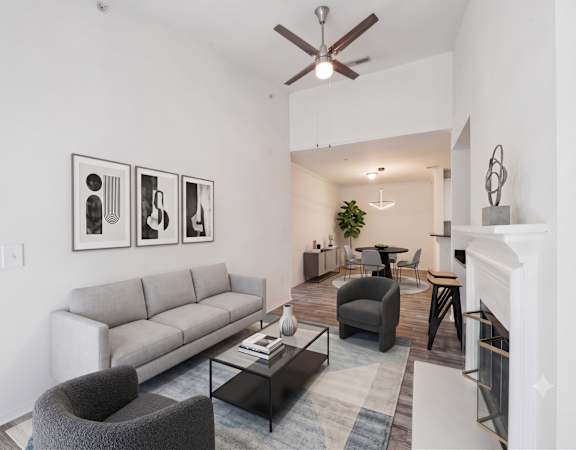A living room with a grey couch, a black coffee table, and a fireplace.