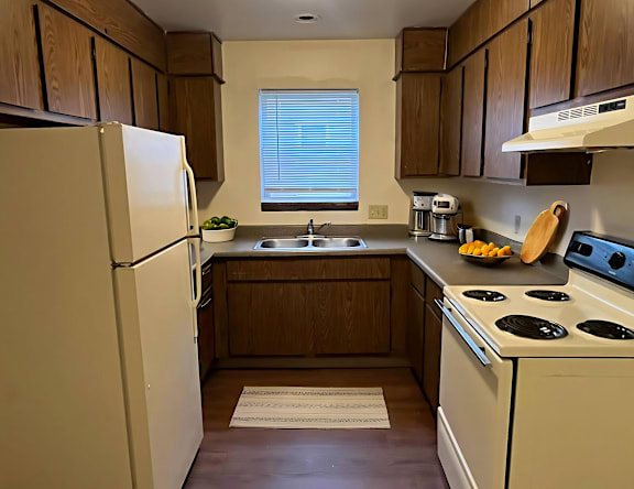 A kitchen with a white refrigerator and a white stove.