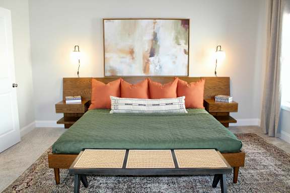 A bed with a green cover and orange pillows is in the image at The Dawson Cartersville in Cartersville, GA 30191