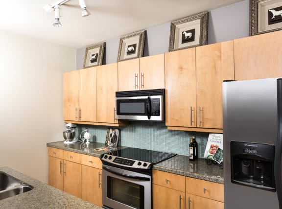 Kitchen with granite counter tops and wooden cabinets at The Heights at Park Lane, Dallas, TX, Texas